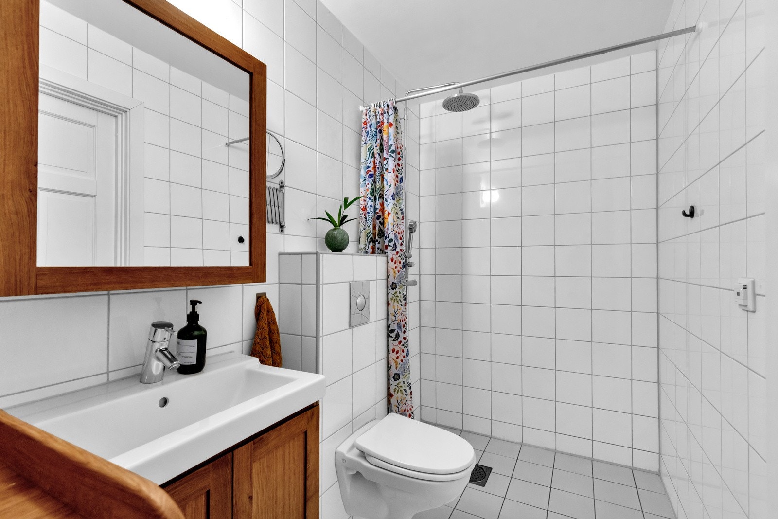Flislagt bad med varmekabler i gulv og opplegg for vaskemaskin. Galleribilde