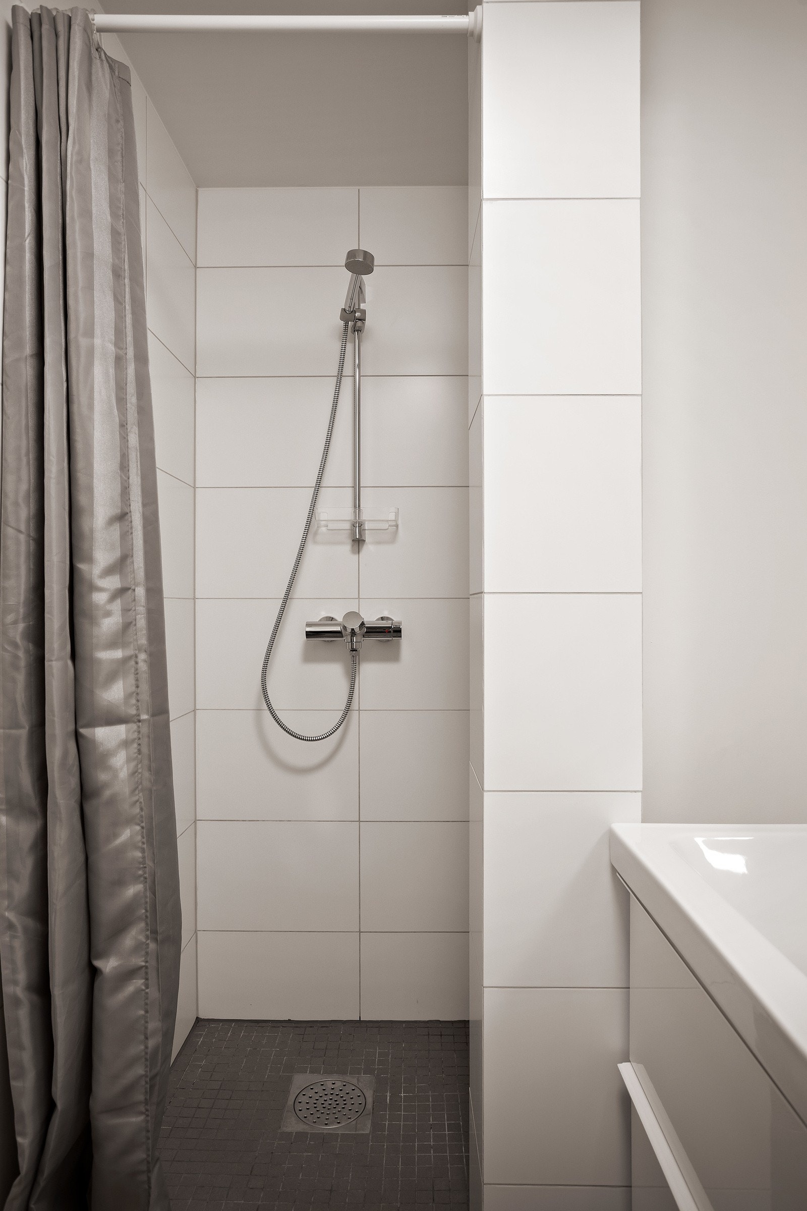 Badet er fra 2018 med flislagt gulv med varme og flislagte vegger i dusjsonen Galleribilde