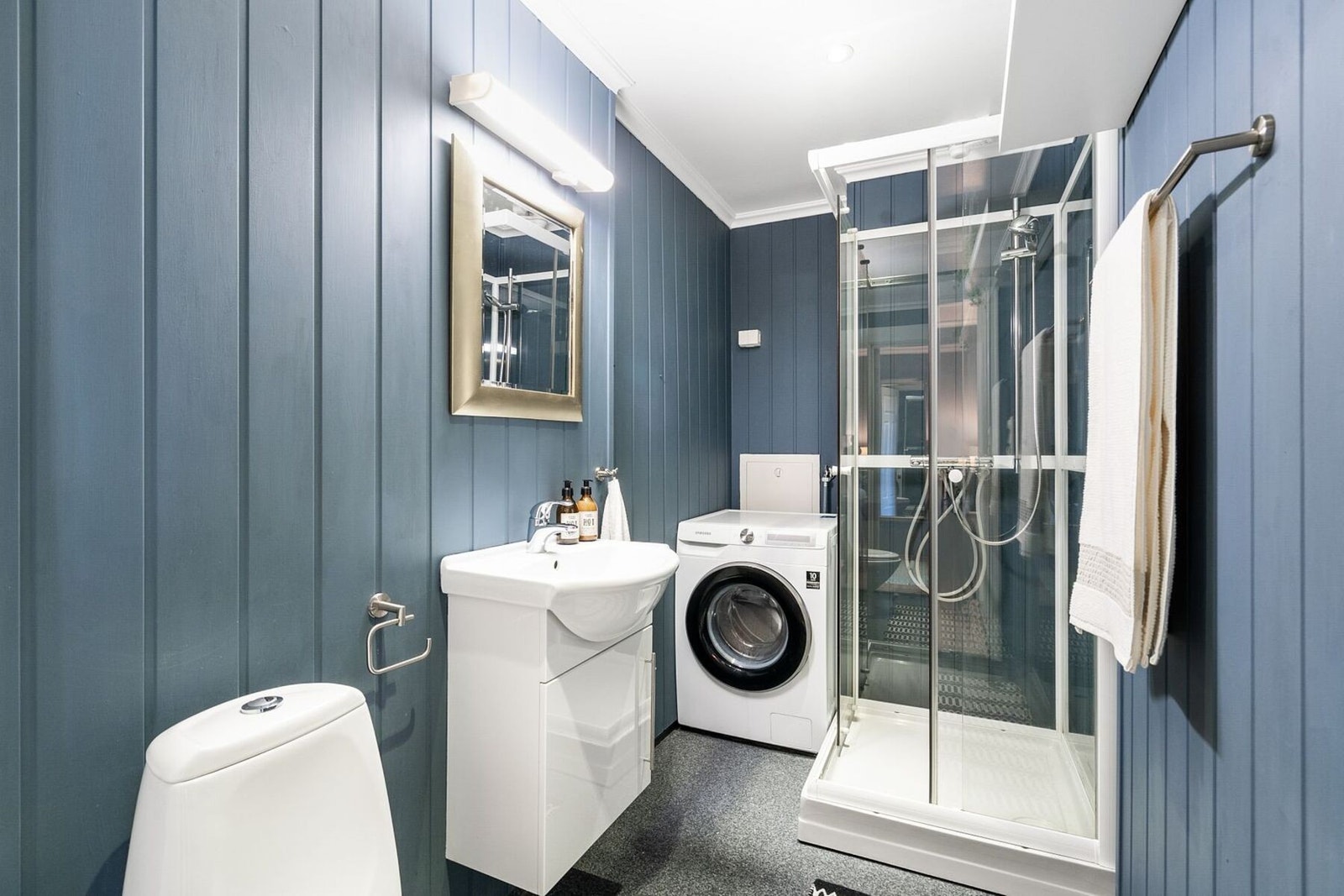 Badet har dusjkabinett og opplegg til vaskemaskin Galleribilde