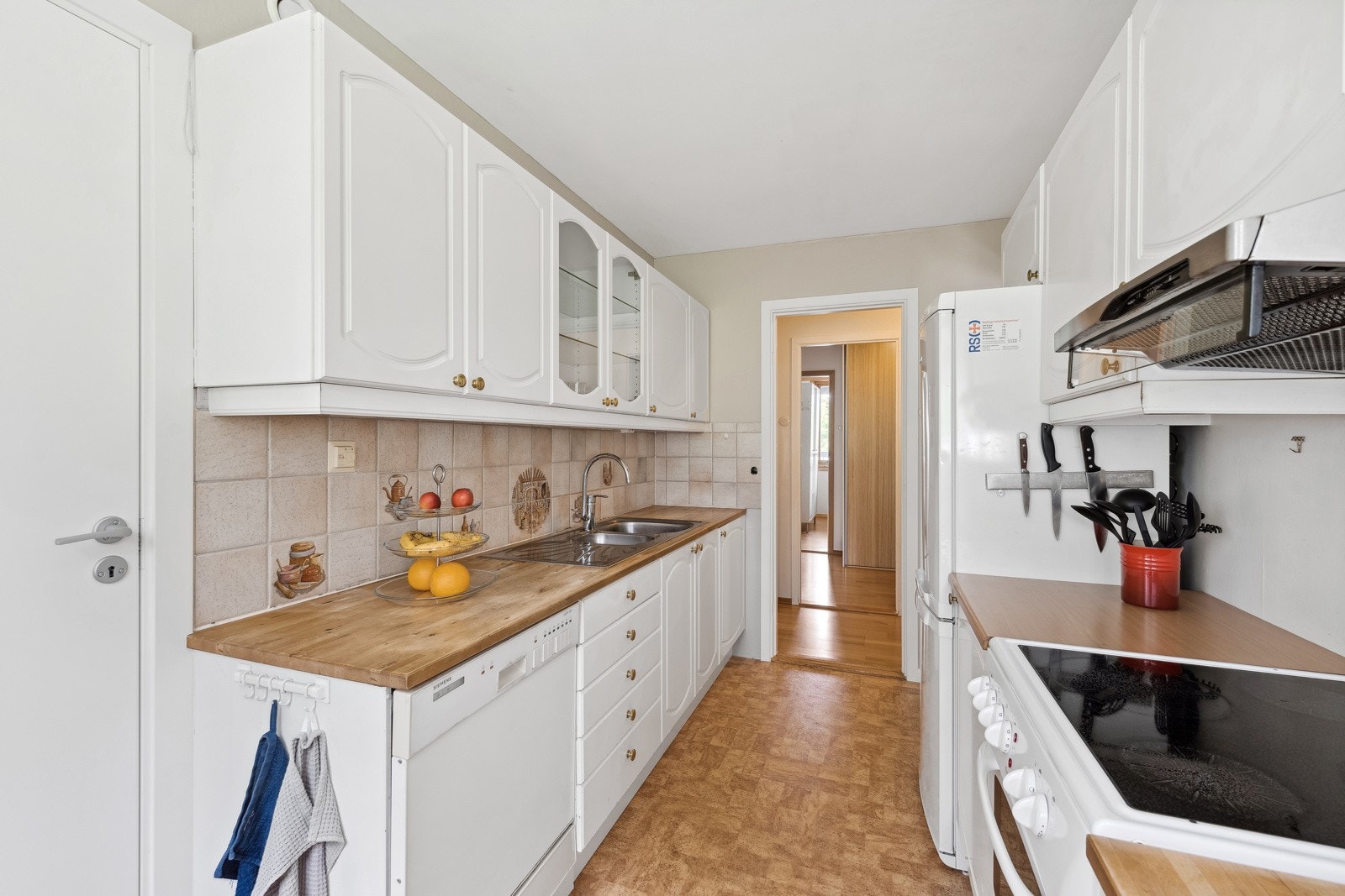 Noe eldre kjøkkeninnredning med hvite, profilerte fronter Galleribilde