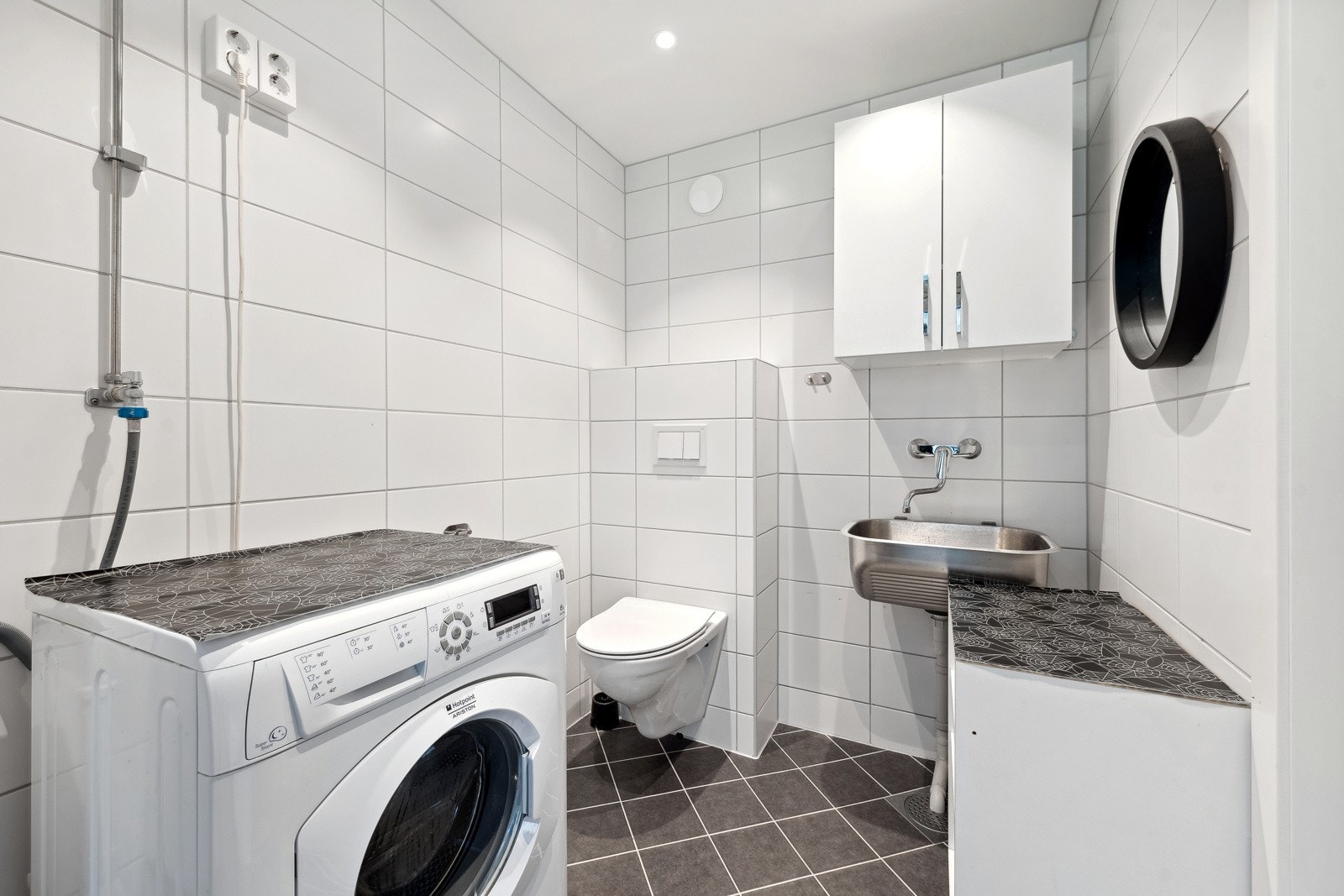 Meget praktisk og flislagt baderom fra 2023 med utslagsvask og opplegg for vaskemasking, samt vegghengt skap. Det er gulvvarme på vaskerommet. I forbindelse med oppussingen gjorde eier tilvalg og fikk innstallert vegghengt wc på vaskerommet. Galleribilde