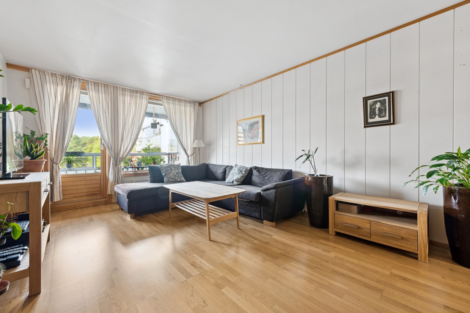 Stuen innehar store vindusflater som gir rommet en lys og hyggelig atmosfære Galleribilde