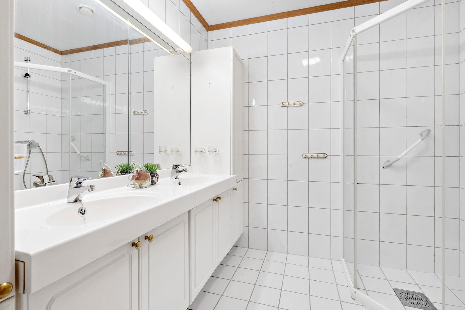 Badet er innreidd med dobbel servant i underskap, dushjørne, klosett og bidé Galleribilde