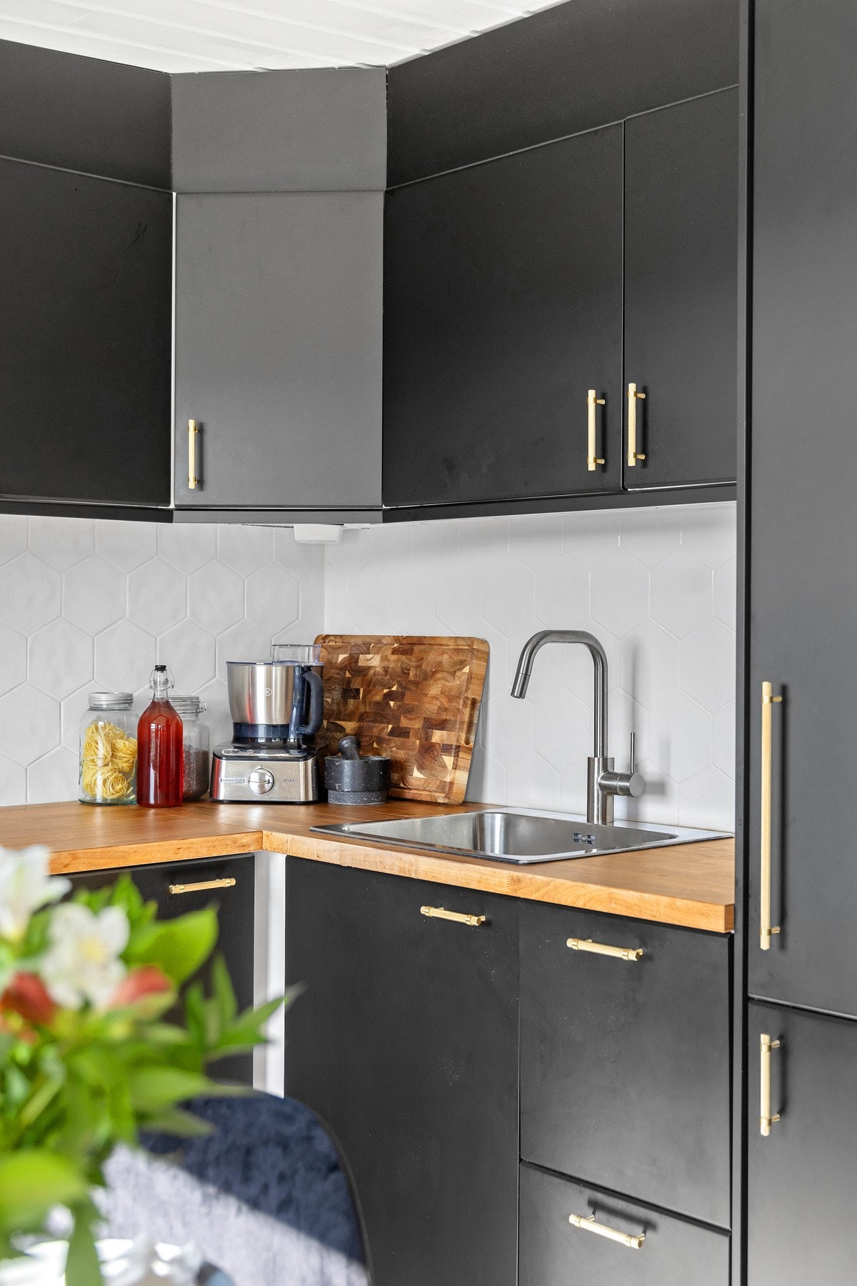 Det er fliser mellom benk og overskap, i tillegg til benkeskapsbelysning og stikkontakter under skapene Galleribilde