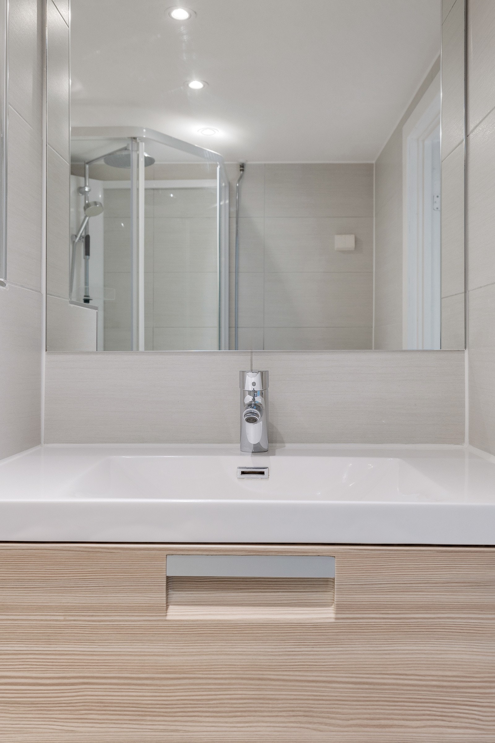 Badet er lyst og tidløst og har downlights i himling. Galleribilde
