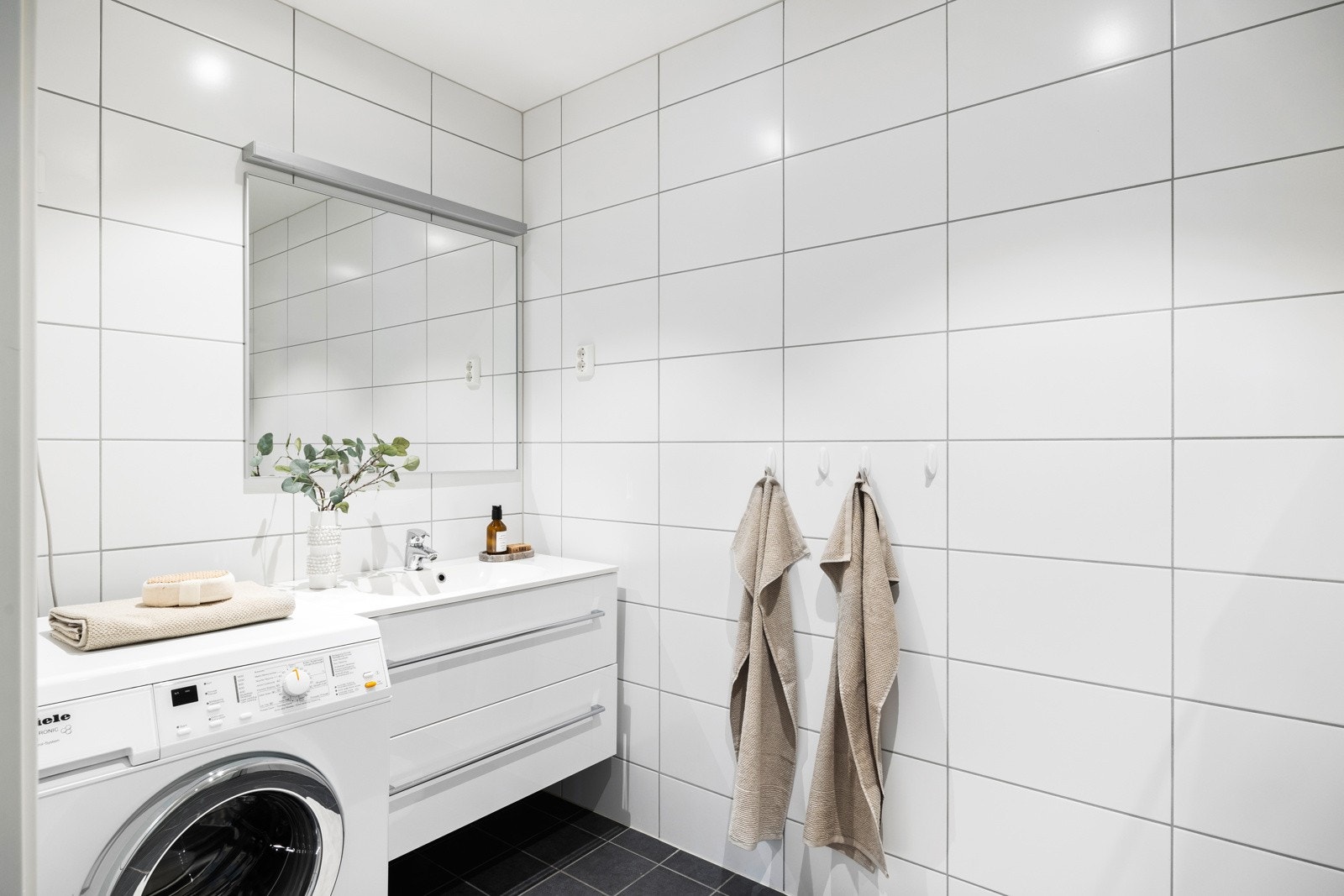 Fliselagt lyst bad med fine kontraster mellom gulv og vegg. Galleribilde