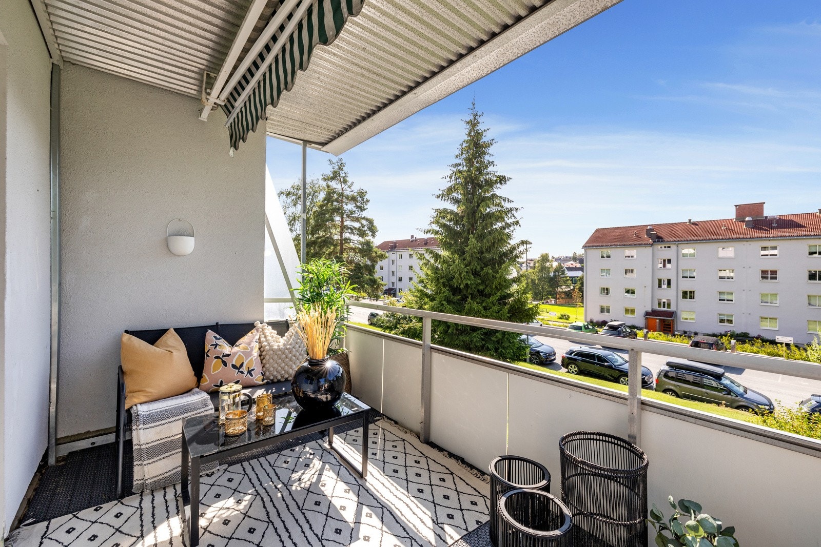 Romslig, overbygd balkong med markise og store grøntarealer utenfor. Galleribilde