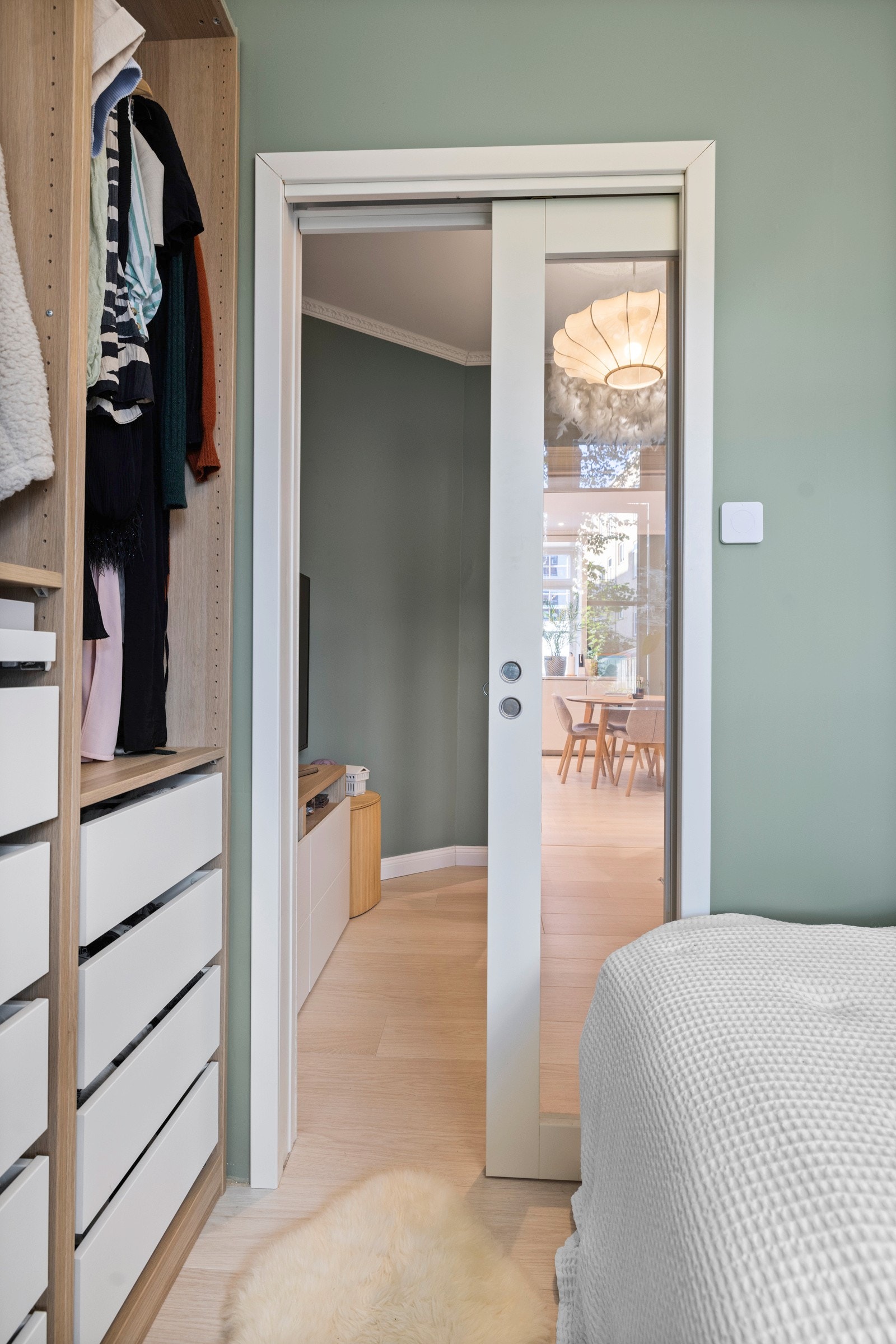 En dør med stort glassfelt skiller mellom soverommet og stuen Galleribilde