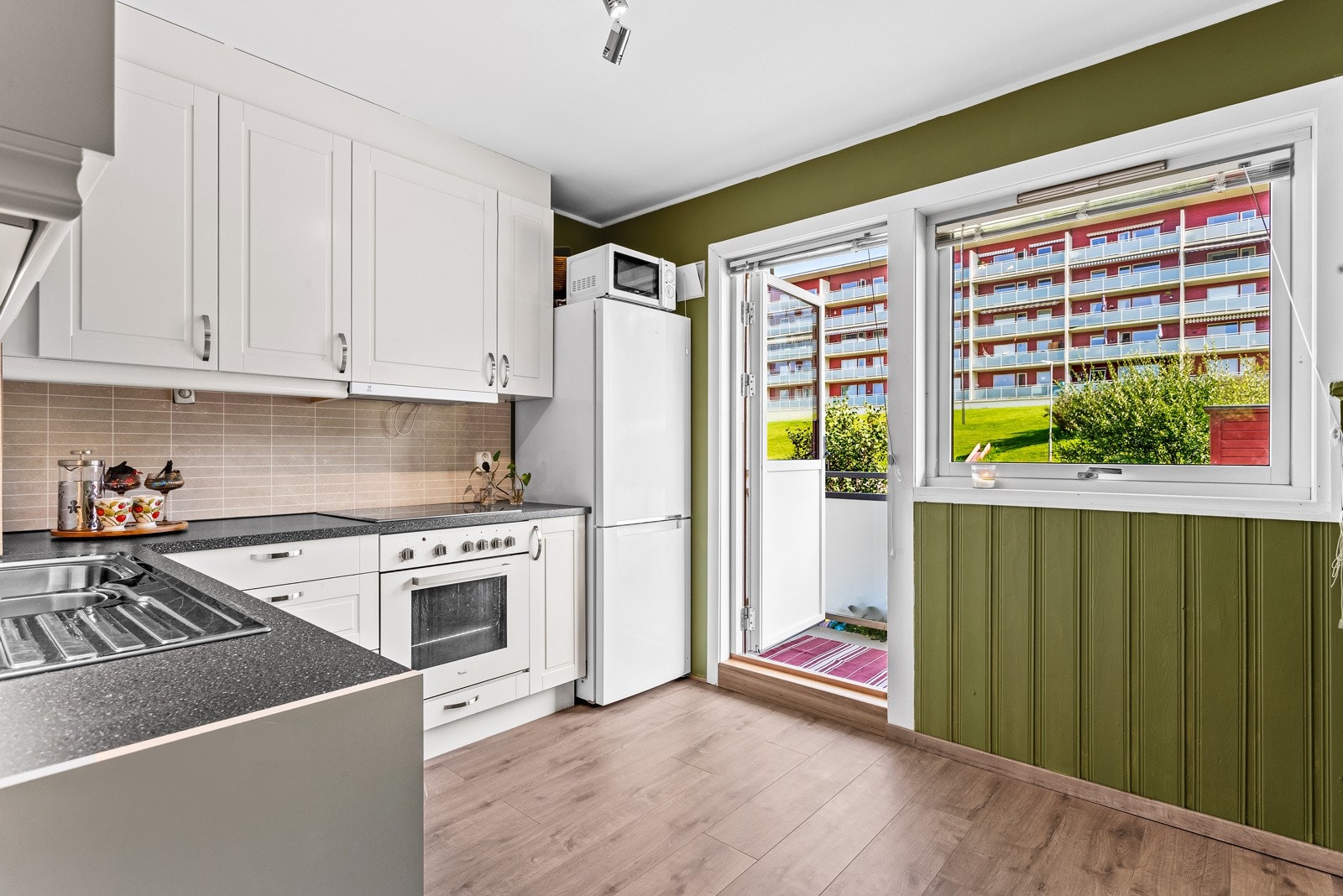 Adskilt kjøkken av god størrelse. Klassisk takhøy innredning fra Norema med mørk benkeplate og flislignende plater på vegg. Galleribilde