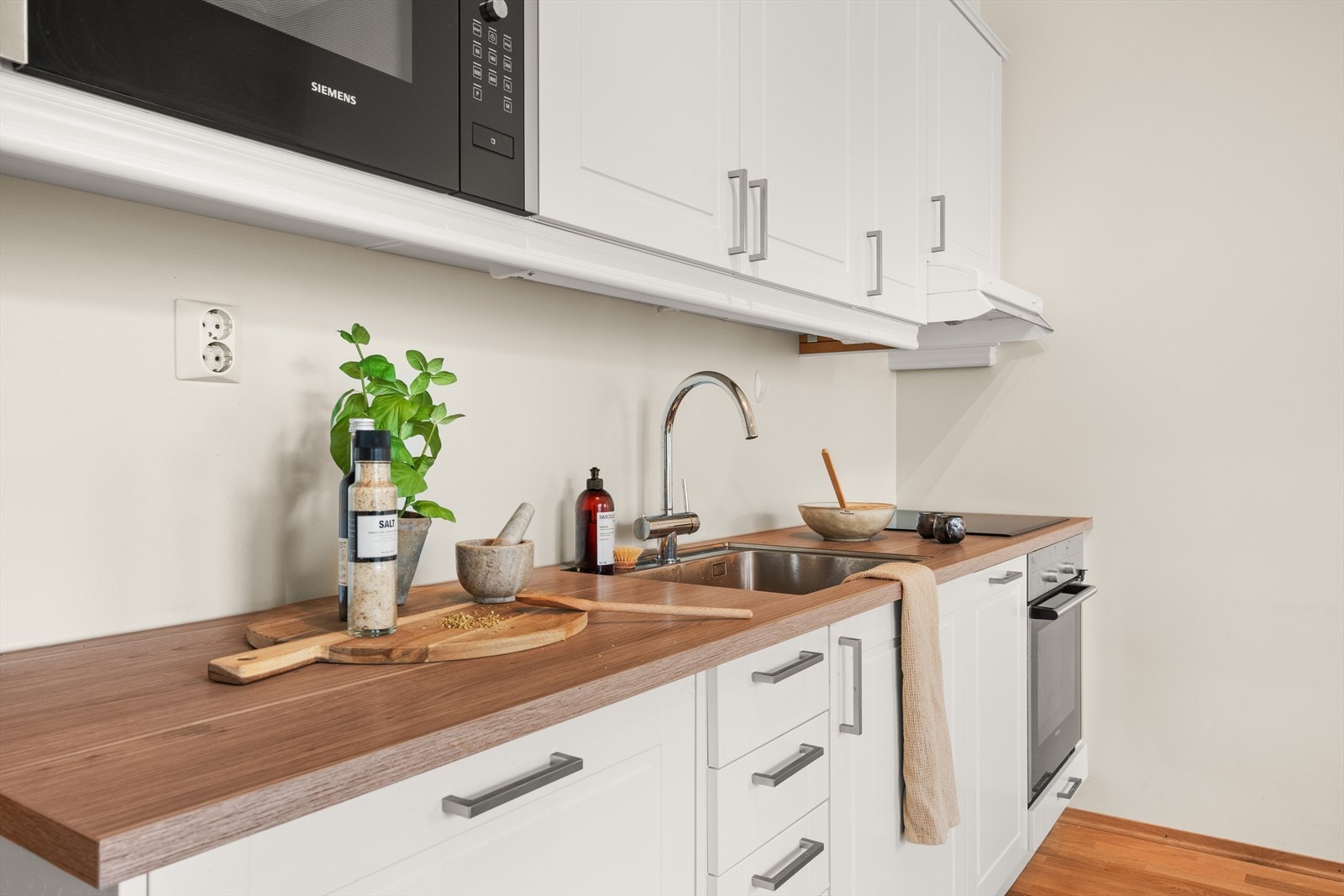 Av integrerte hvitevarer finner vi induksjonsplatetopp, stekeovn, oppvaskmaskin, mikrobølgeovn, kjøl og frys Galleribilde