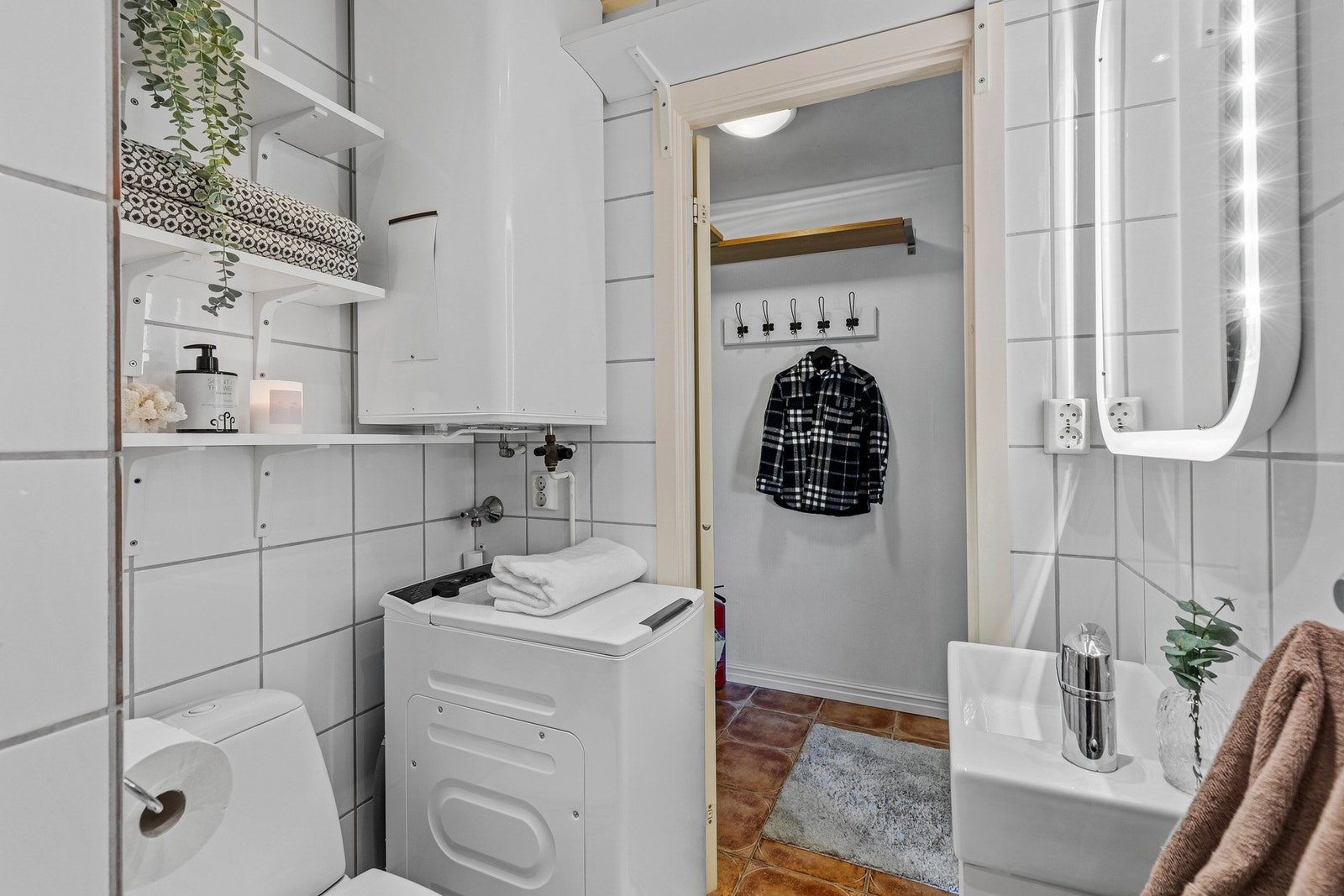 Flislagt bad på 3 kvm utstyrt med baderomsinnredning, klosett og dusjhjørne. Varmtvannstanken er plassert på badet. Galleribilde