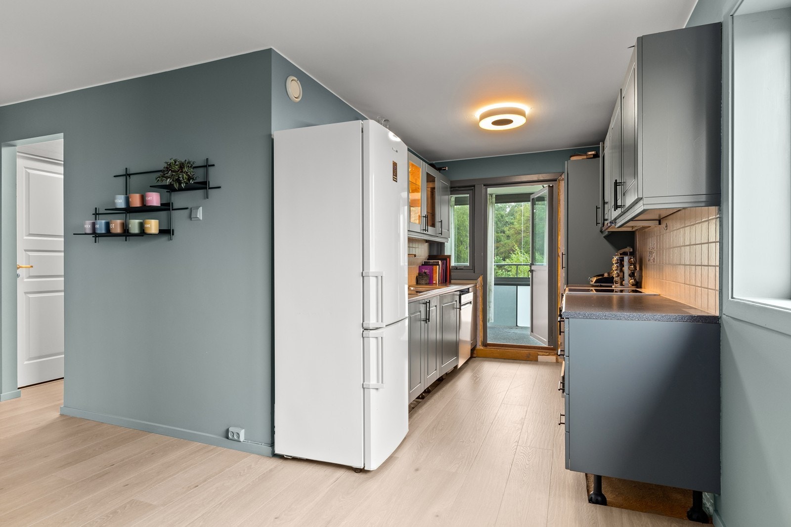 Kjøkkenet har innredning med profilerte fronter og laminat benkeplate Galleribilde