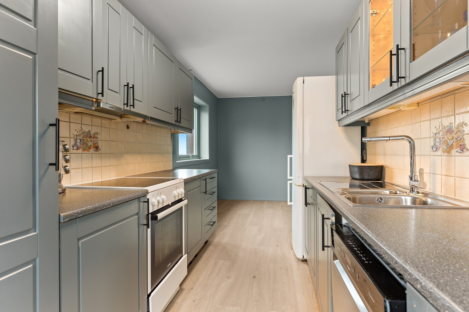 Kjøkkenet har plass til frittstående hvitevarer og det er kjøkkenventilator med avtrekk ut Galleribilde