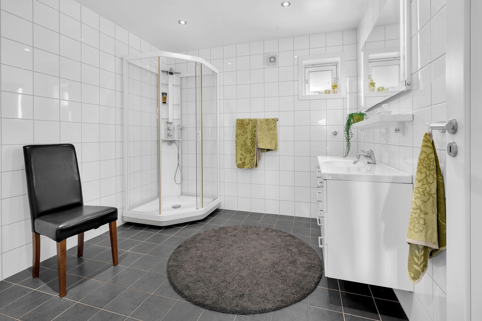 Lekkert, stort og flislagt bad både på vegger og gulv med spotdownlights i tak. Galleribilde