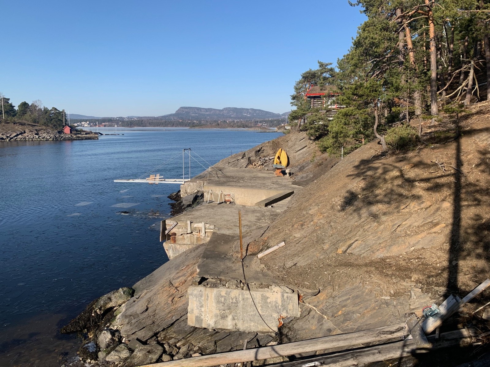 To betongplattinger/brygger, en enkel "slipp" med vinsjanordning, èn Tønsbergbrygge og et lite strandhus på strandparsellen. Galleribilde