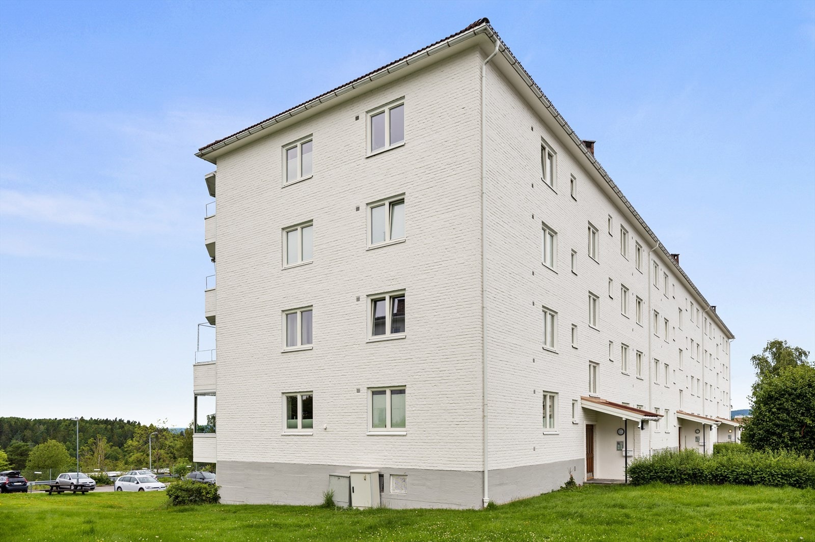 Fasade av leilighetsbygg med grønne omgivelser. Galleribilde