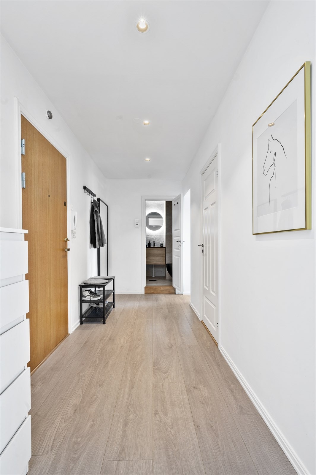 Lang gang med lyse gulv og god plass til oppbevaring. Galleribilde