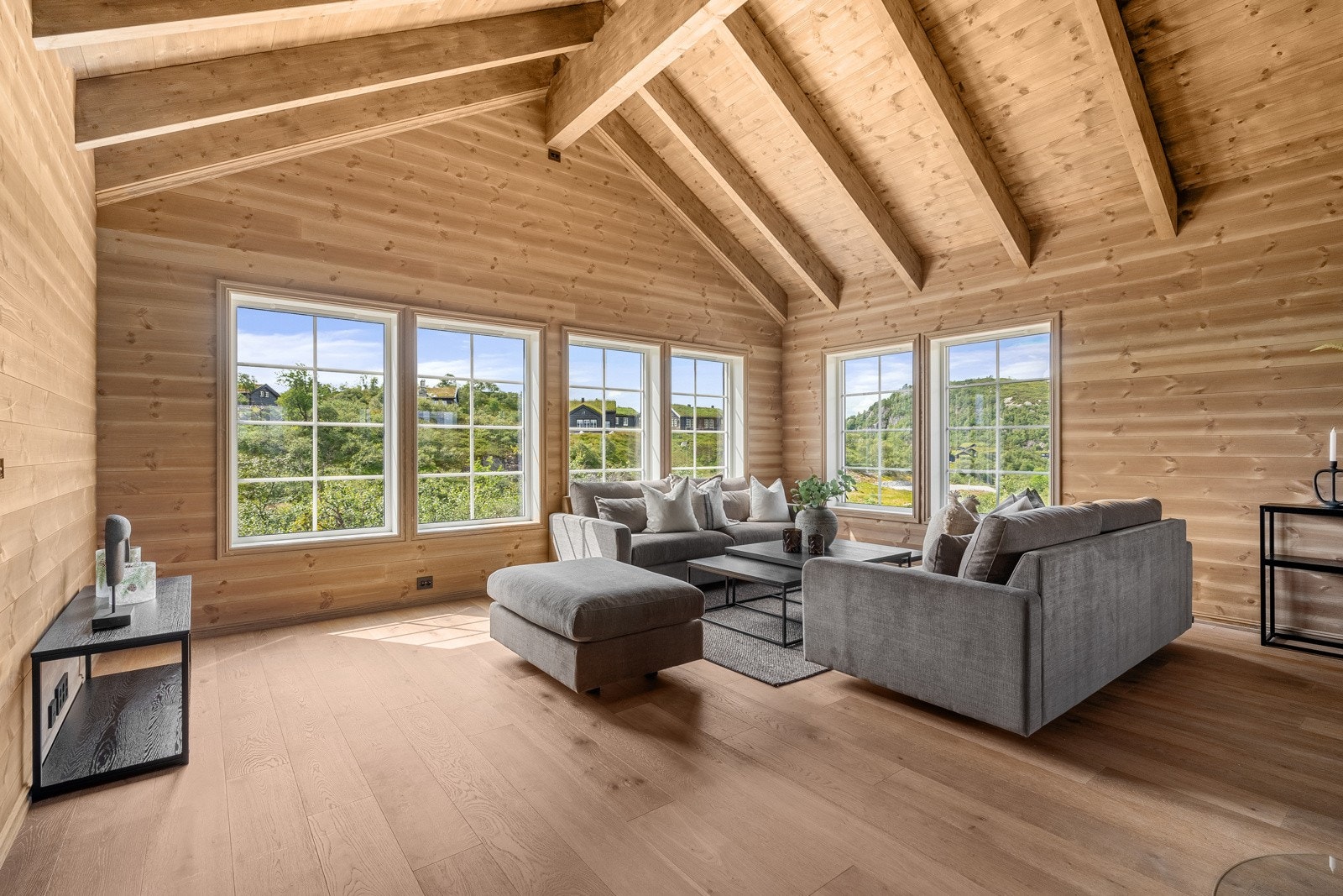 Stuen fremstår lys med mange vindu som slipper inn mye naturlig lys Galleribilde