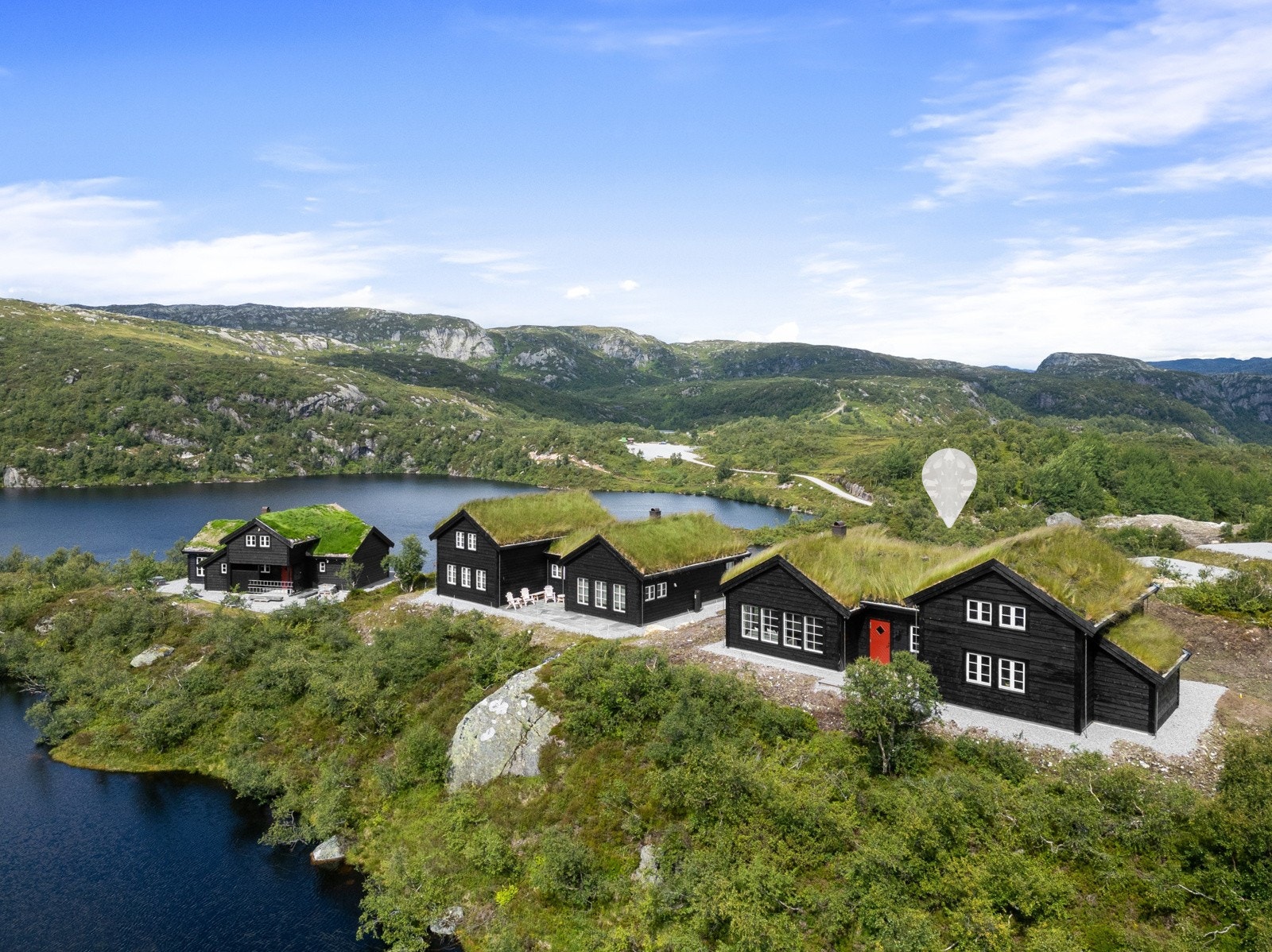 Hytten ligger på en høyde i terrenget ut mot et lite tjern Galleribilde