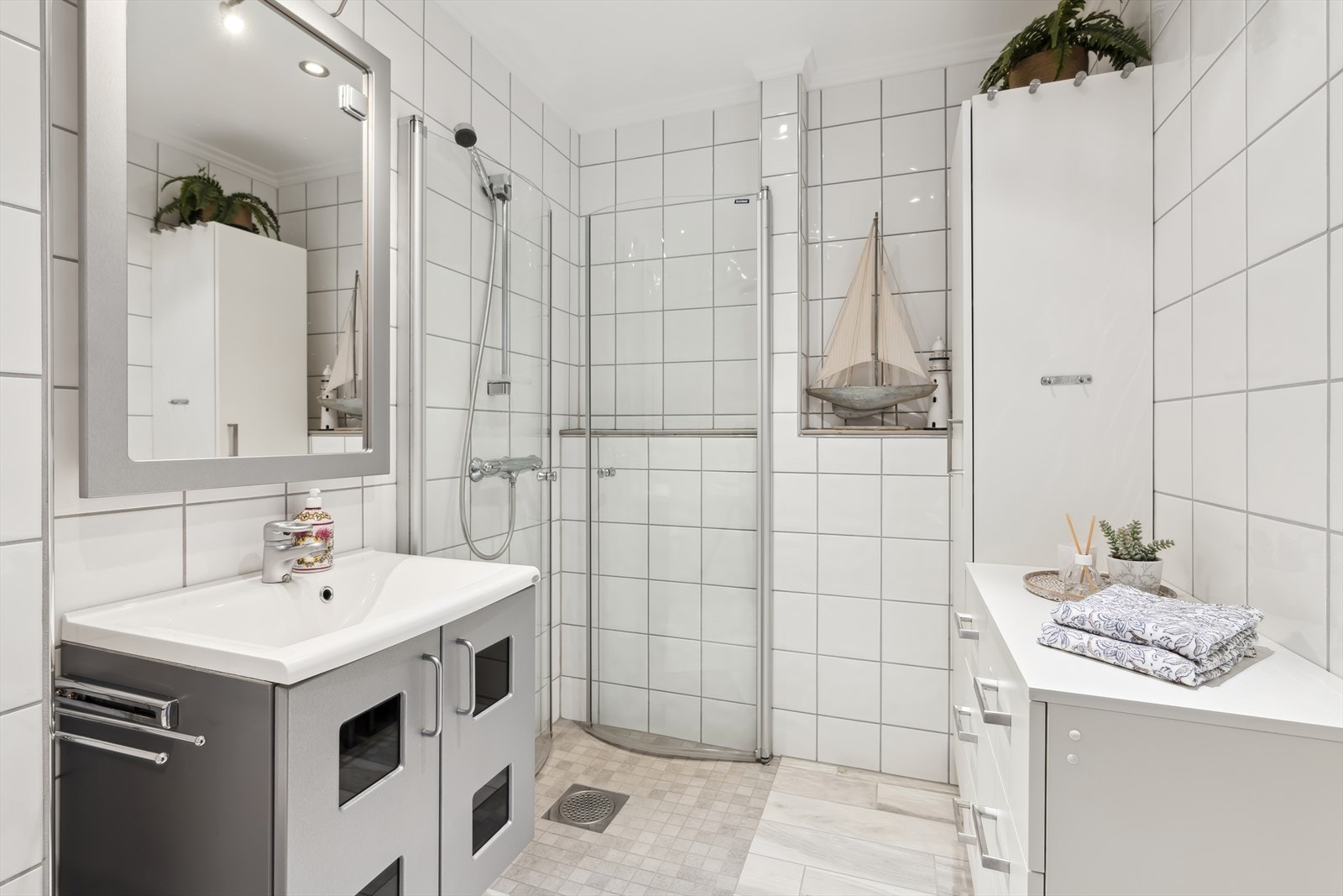 I boligens underetasje finner vi videre et lyst og pent baderom. Badet er gjennomført med pene fliser på gulv og vegger. Galleribilde