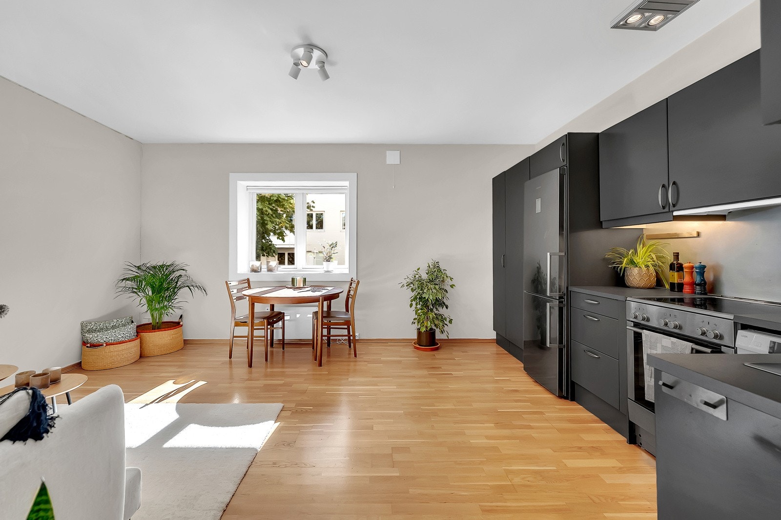 Vinduer på to sider gir stuen rikelig med naturlig lys og en svært god atmosfære - Malte flater og parkett Galleribilde