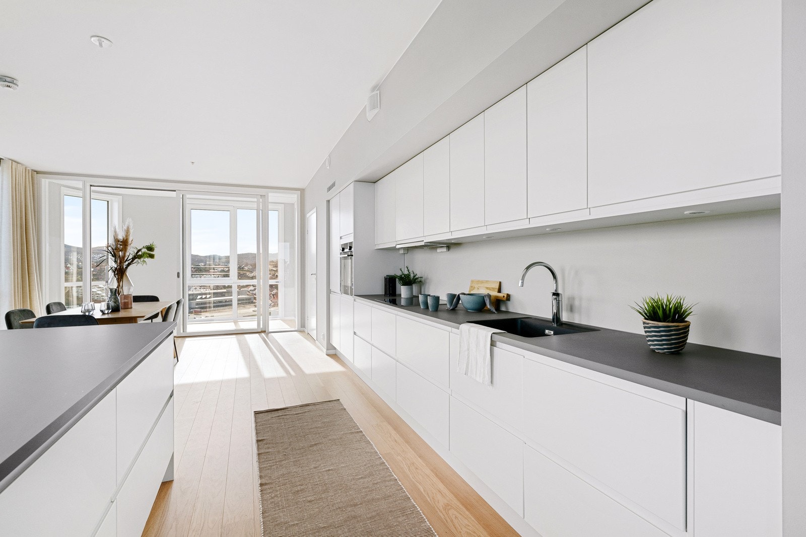 Praktisk hvit kjøkkeninnredning med integrerte hvitevarer Galleribilde