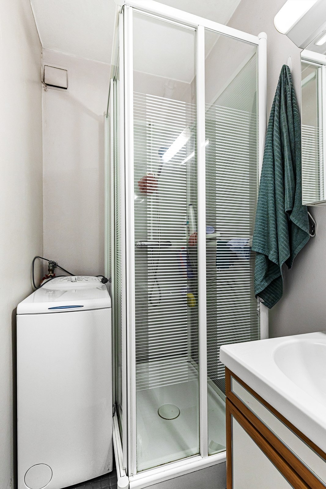 Bad er lagt med fliser på gulv og betongvegger og har opplegg for vaskemaskin. Galleribilde