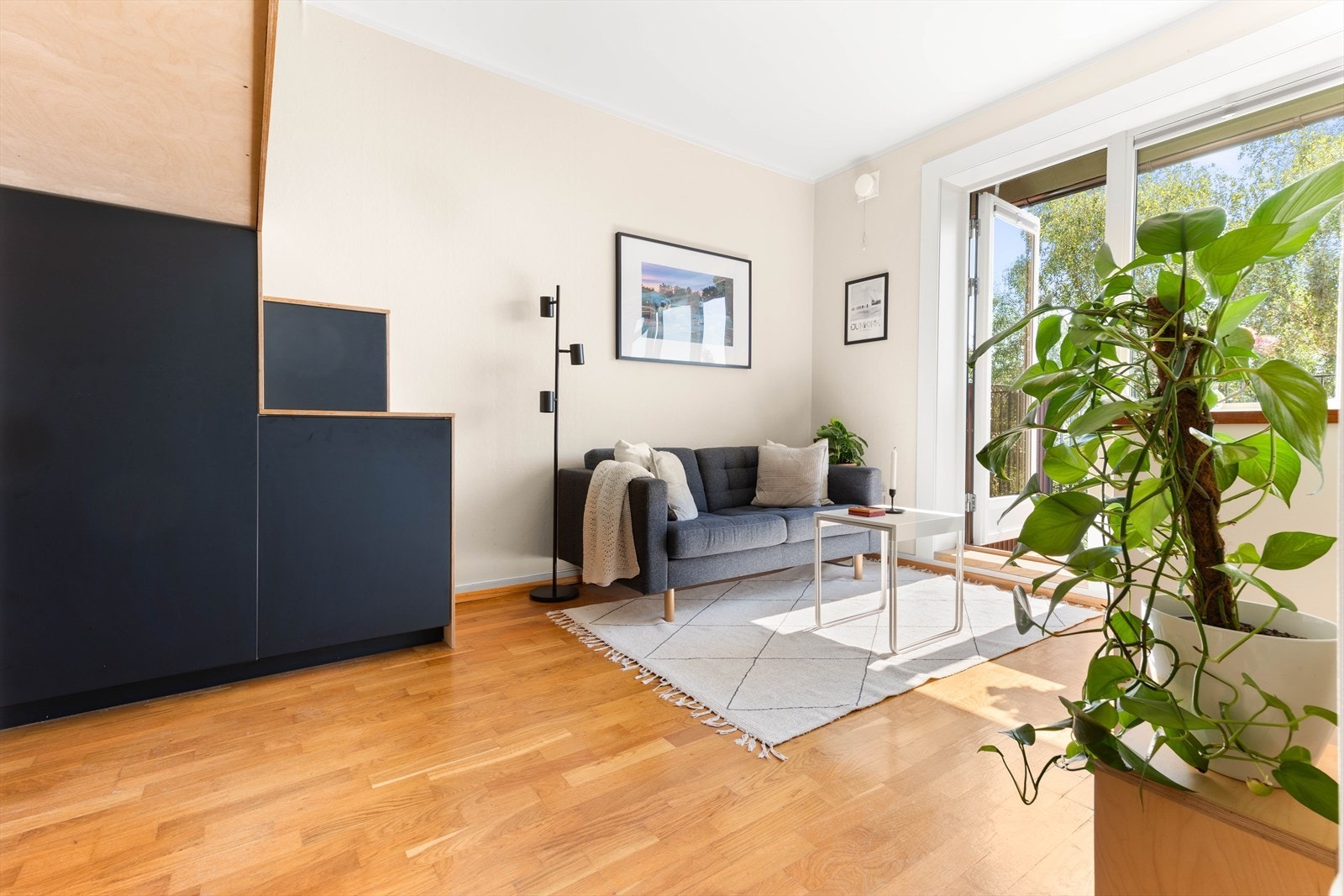 Et romslig og arealeffektivt oppholdsrom med plass til en sofa, salongbord, tv og mediemøblement. Galleribilde