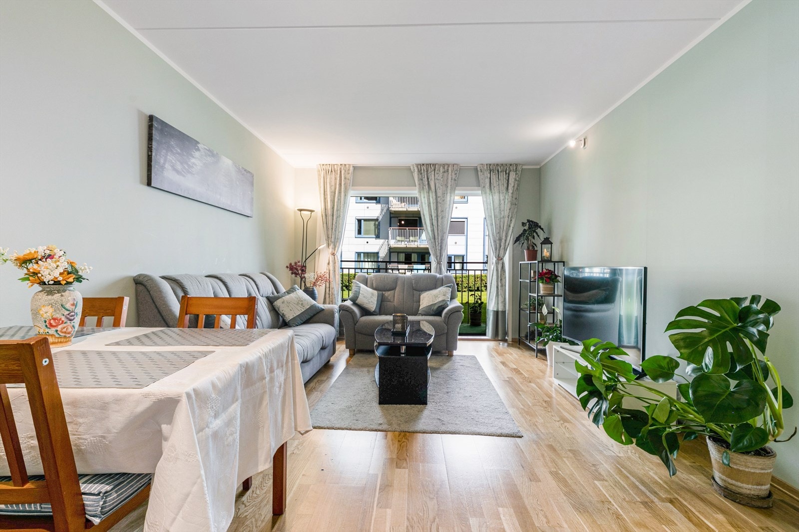 Her får du et vel gjennomført oppholdsrom med tidsriktige, duse farger på vegger i fin kombinasjon med parkett på gulv. Galleribilde