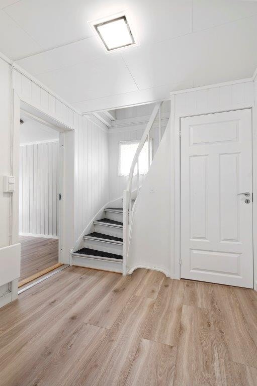 Mellomgang i 1. etasje med trapp opp. Rommet ble oppmalt i 2017. Inn døren finner du trappen ned til kjelleren. Galleribilde