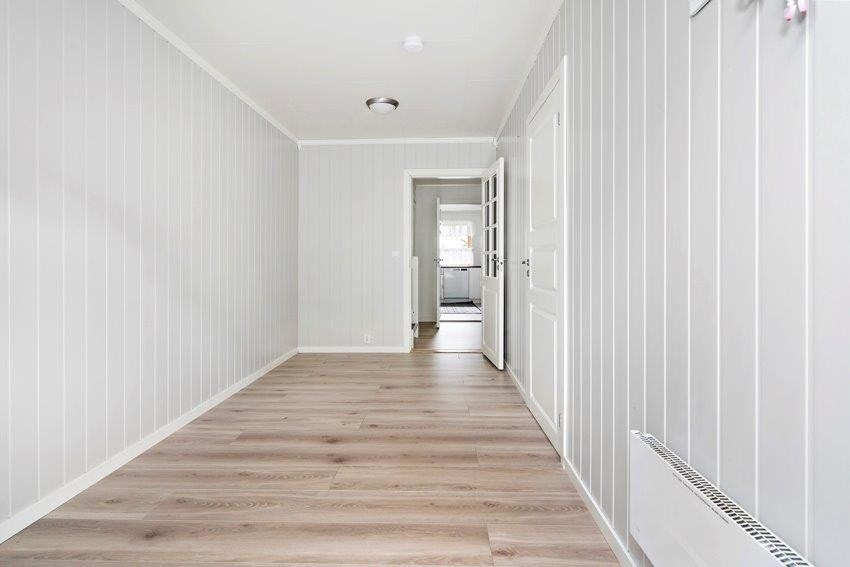 Romslig gang med god plass for garderobeskap - og oppbevaring. Inn døren til høyre finner du badet. Inngangspartiet, gangen og badet ble tilbygget i 2009. Galleribilde