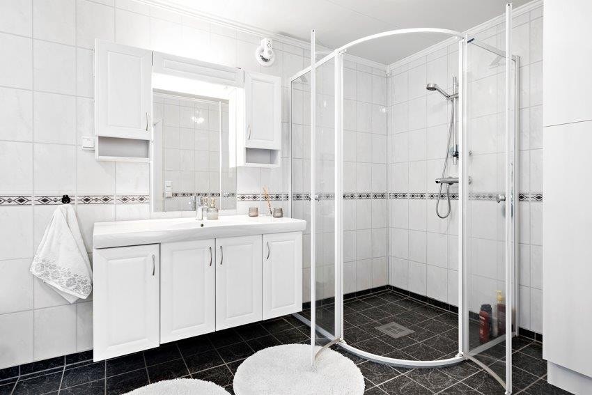 På veggene er det baderomsplater mens det er fliser på gulv - med elektriske varmekabler. Galleribilde