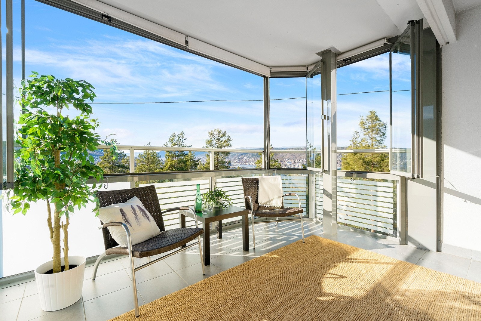 Balkongen er stor og flislagt på 12m². Glassene kan skyves til siden og åpnes etter ønske og behov. Her er det god plass til utemøblement Galleribilde