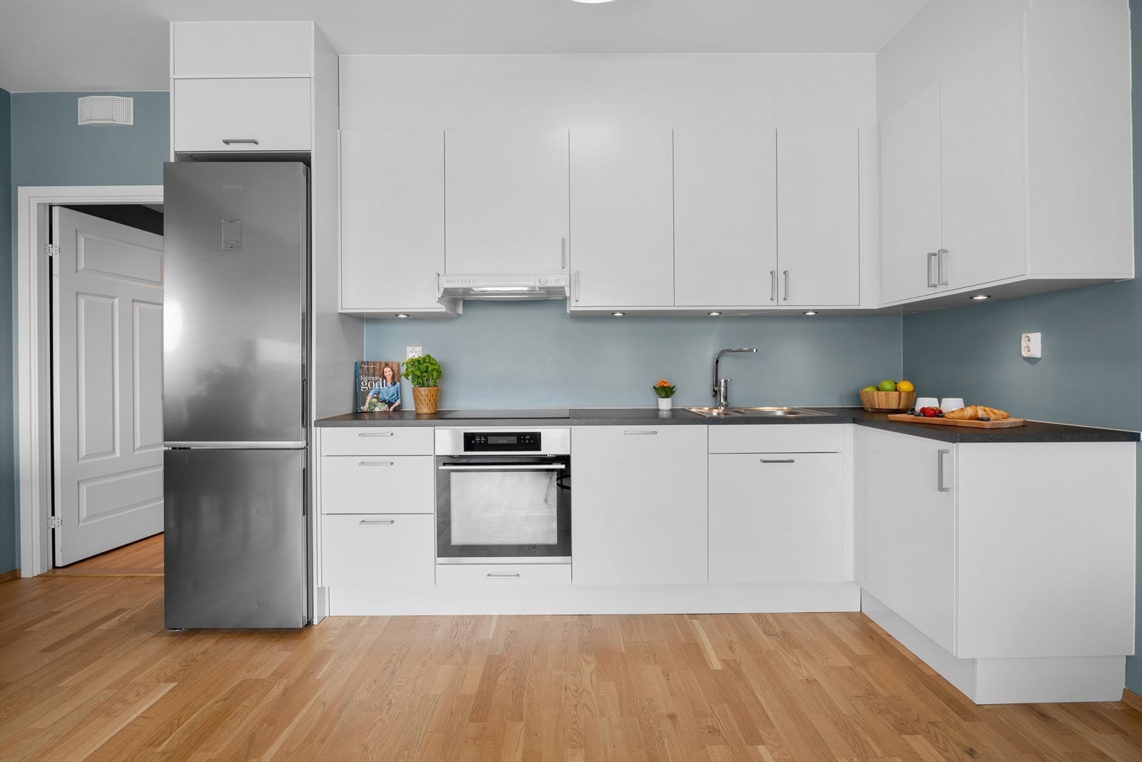 Moderne kjøkken med rikelig med skap- og benkeplass. Kjøkkeninnredning med glatte fronter og laminat benkeplate med nedfelt kum i rustfritt stål. Galleribilde