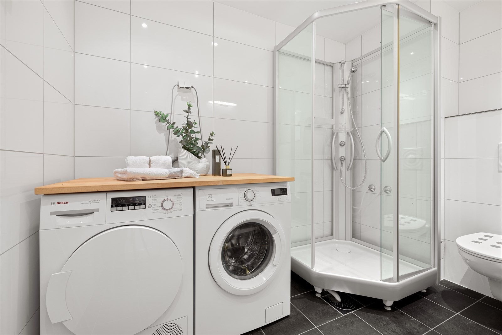 Badet som har tilgang fra soverommet har et dedikert område for vaskemaskinen og eventuelle ekstra lagrings og- oppbevaringsmuligheter. Galleribilde