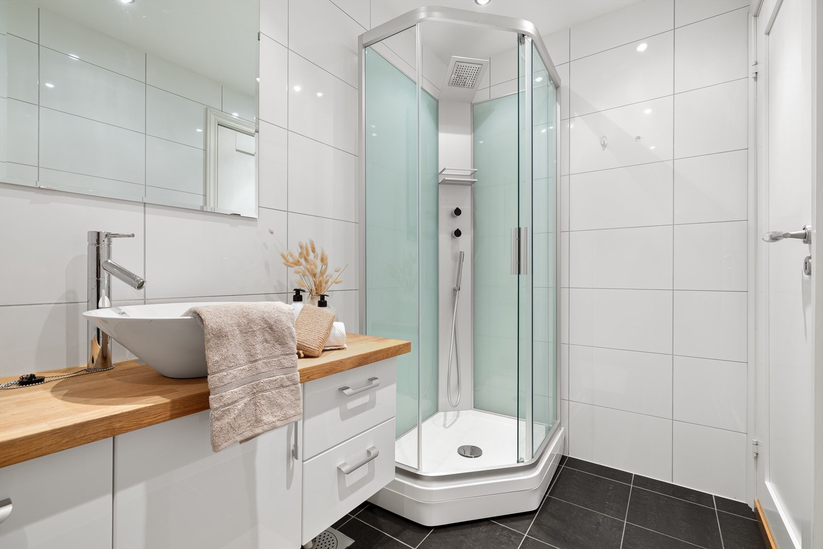 Badet er utstyrt med alle nødvendige fasiliteter, inkludert servant, vegghengt toalett og dusjkabinett. Galleribilde
