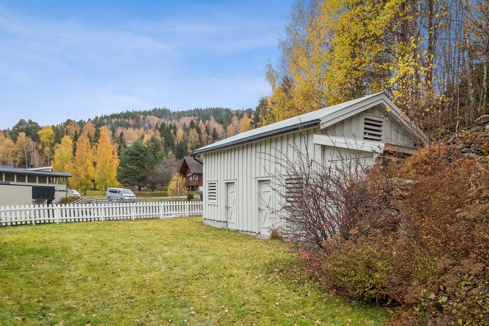 Terrassert platå på oversiden med plen og adkomst til romslig uthus Galleribilde