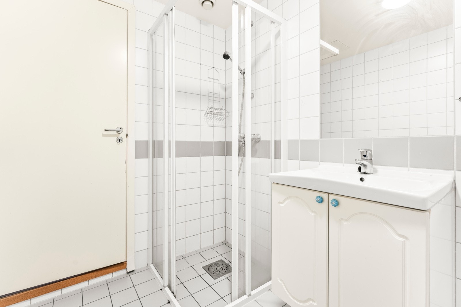 Badet inkluderer dusj på gulv, servant i helstøpt plate og gulvstående klosett. Galleribilde
