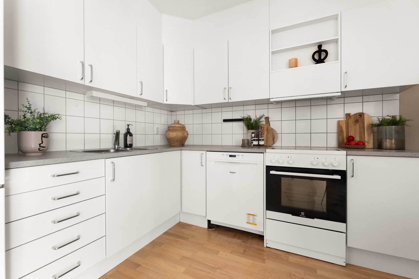Innredningen består av glatte fronter, laminat benkeplate med nedfelt kum i rustfritt stål, fliser på vegg over benkeskap samt opplegg for oppvaskmaskin. Galleribilde