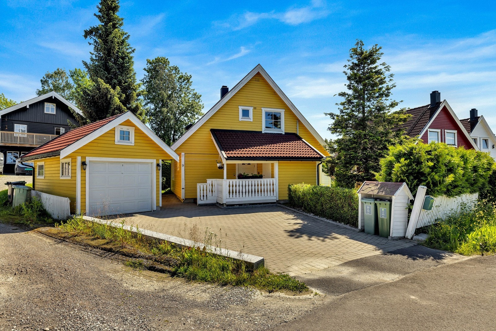 Parkering på steinbelagt gårdsplass og i garasje fra 2001 med elektrisk leddport og ladepunkt for elbil. Galleribilde
