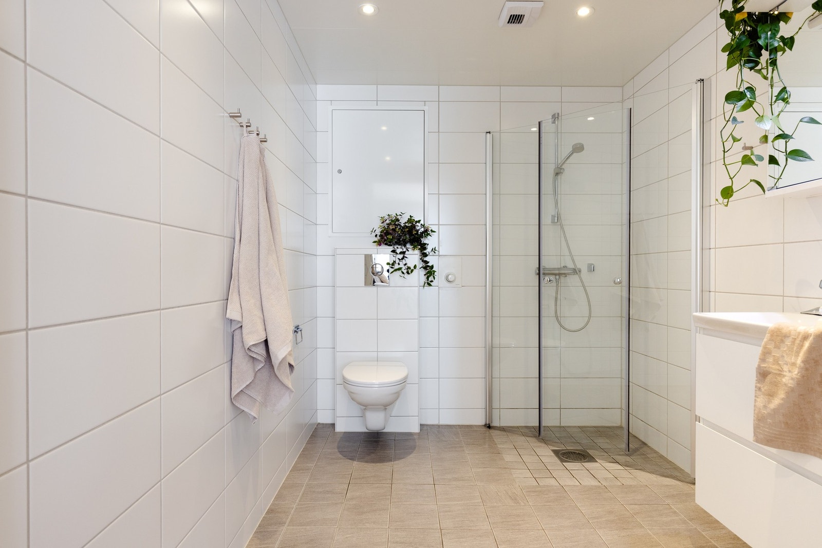 På badet er det innredning med nedfelt servant, veggmontert toalett og dusjvegger/hjørne. Galleribilde