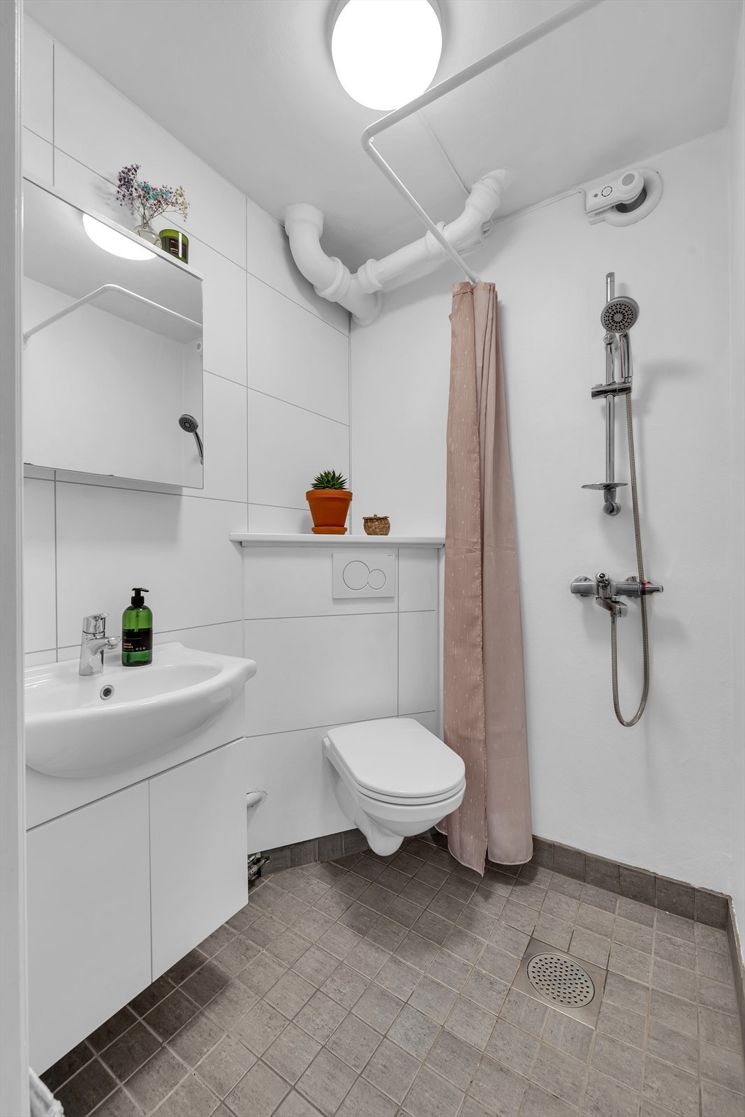 Baderom m/ vegghengt toalett. Felles moderne vaskerom i 1. etasje. Galleribilde