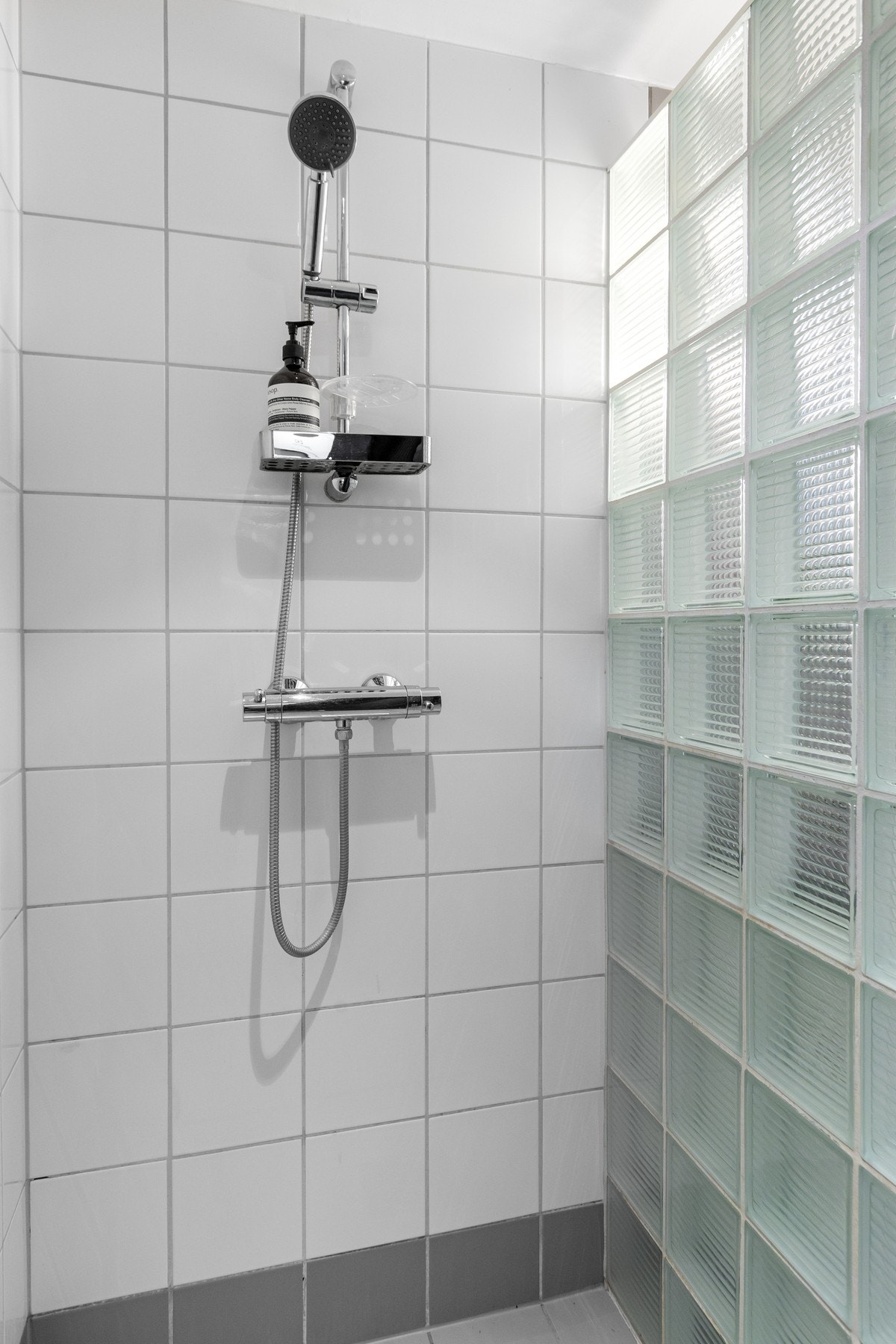 Dushjørne med glassbyggerstein. Dusjarmatur tilkoblet hånddusj. Galleribilde