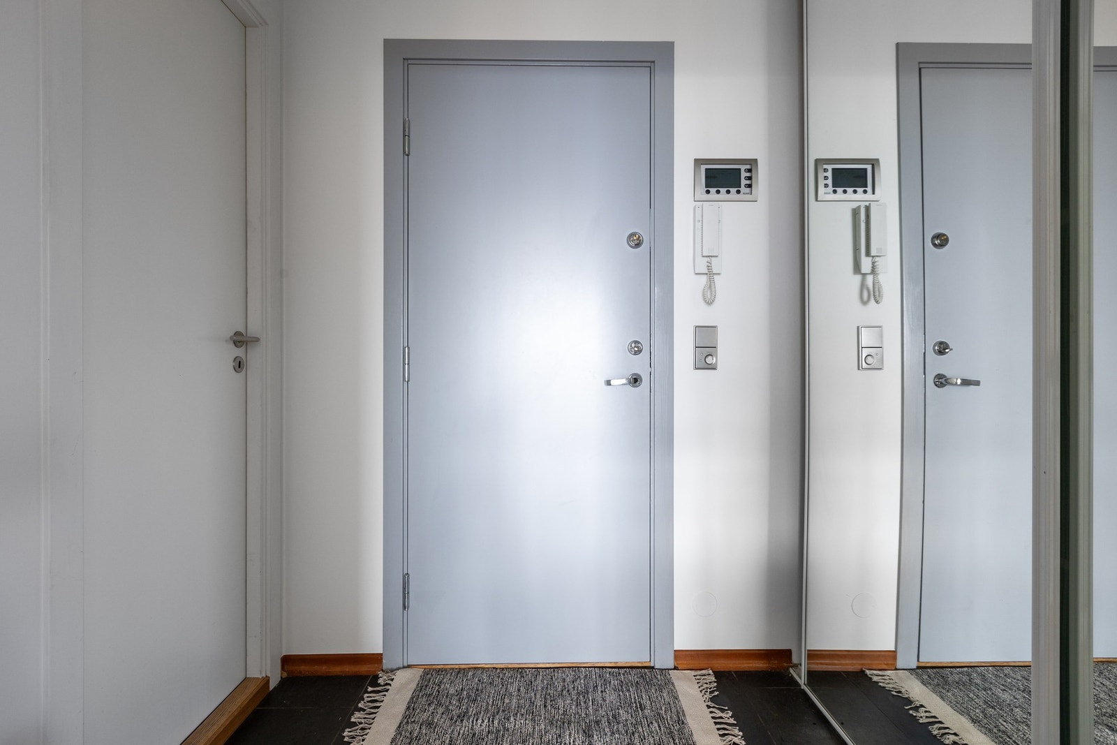 Romslig entré byr på skapplass og kontrollkonsoll for varme-og lysstyring på vegg ved entré. Galleribilde