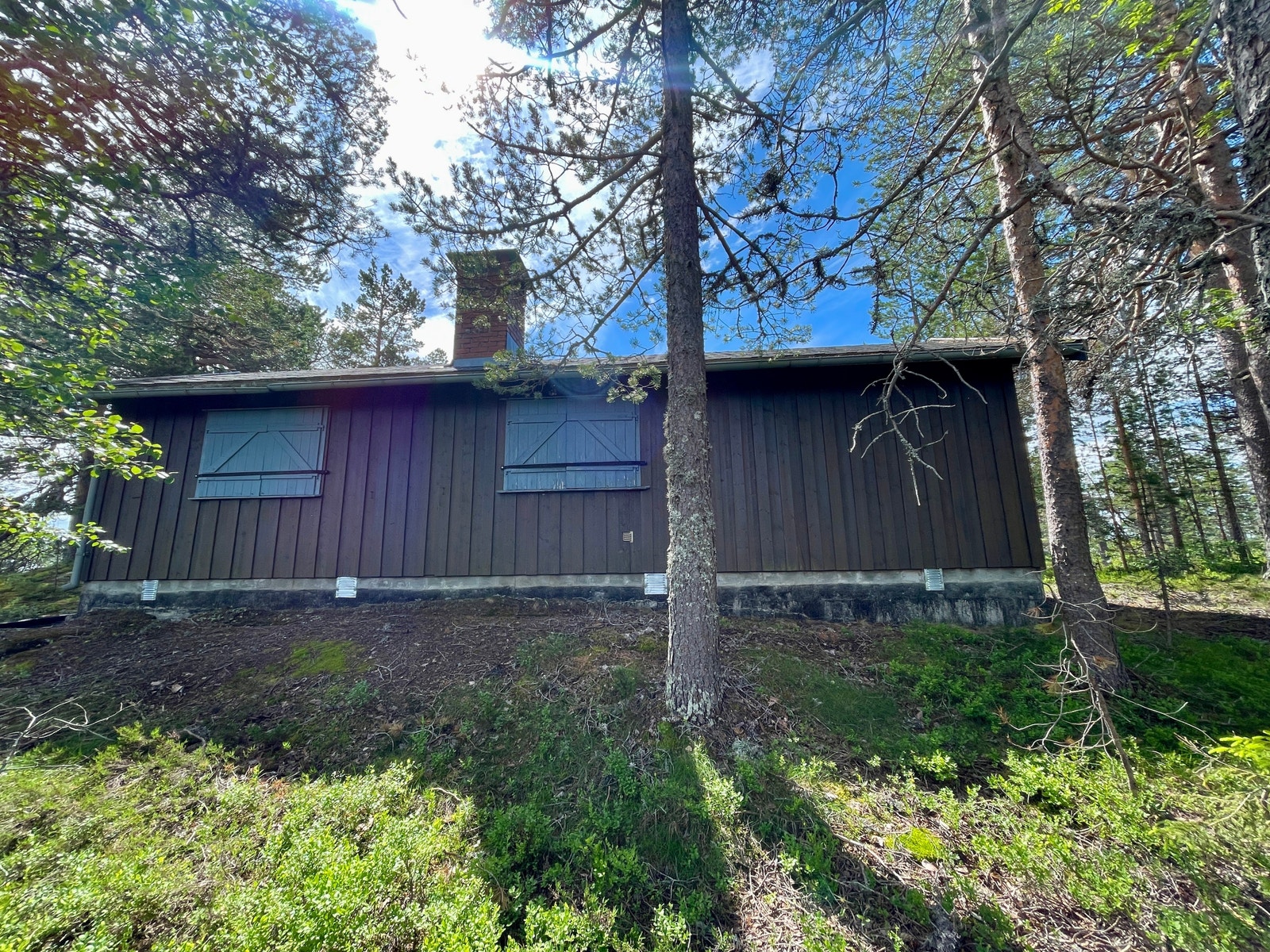 Hytta har stående kledning og er på grunnmur. Galleribilde