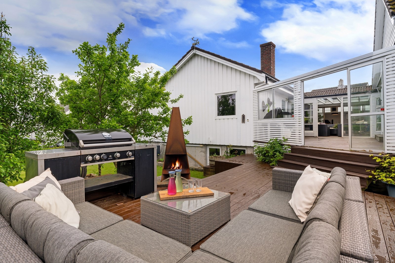 Sol til ca kl 21:30 på eiendommen. Ut fra atrium kommer du til grillområde med flere store møbleringssoner og nedgang til hagen. Boltreplass for alle og perfekt for sosial samling. Galleribilde