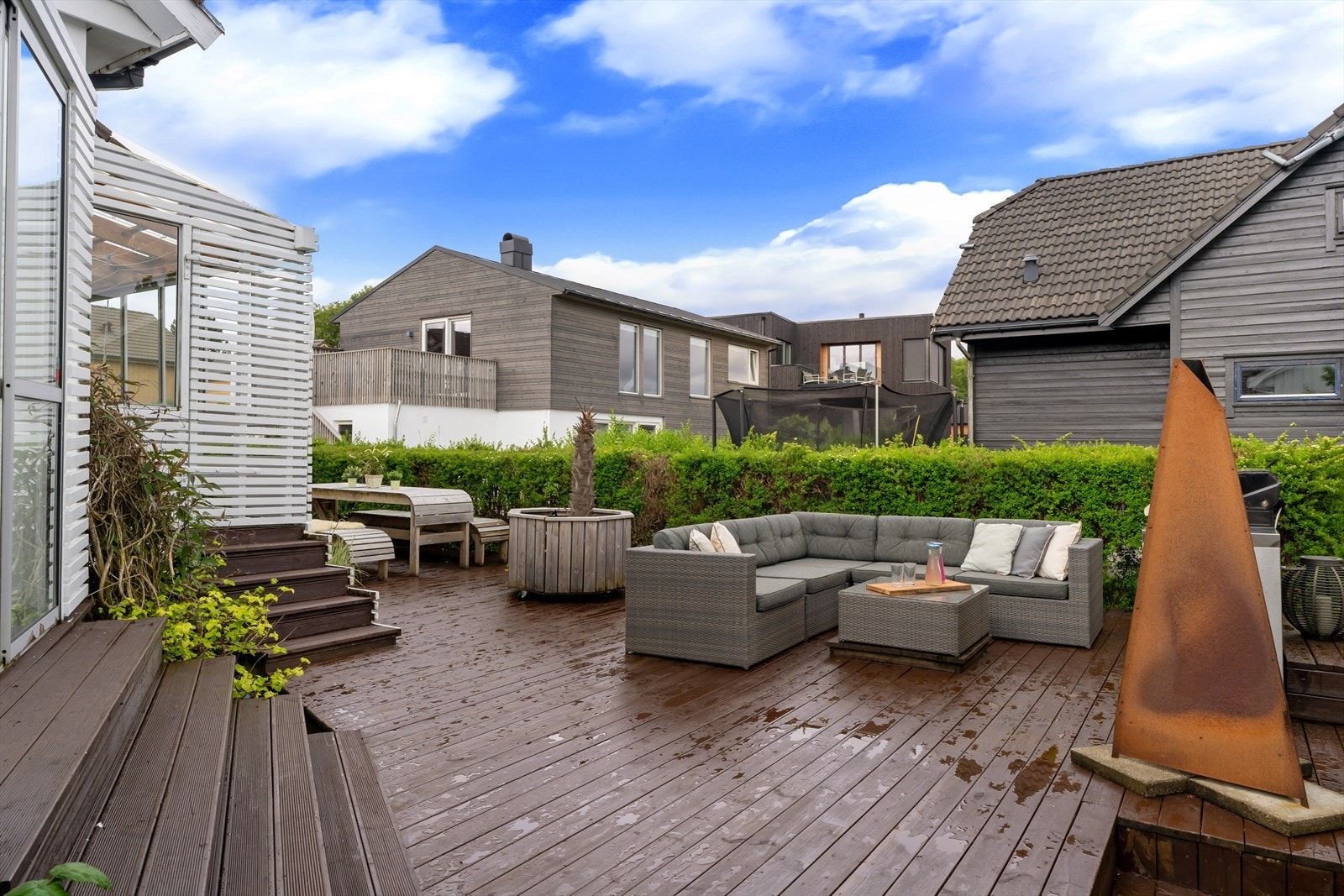 Ut fra atrium kommer du til grillområde med flere store møbleringssoner og nedgang til hagen. Boltreplass for alle og perfekt for sosial samling. Galleribilde