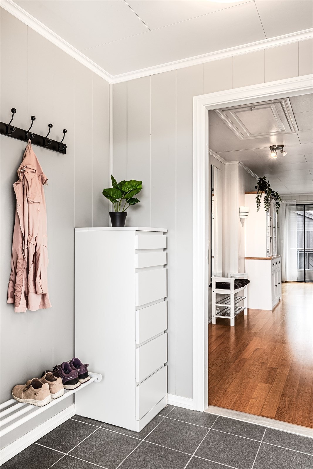Lys og trivelig gang med plass til oppheng av ytterjakke og sko. Galleribilde