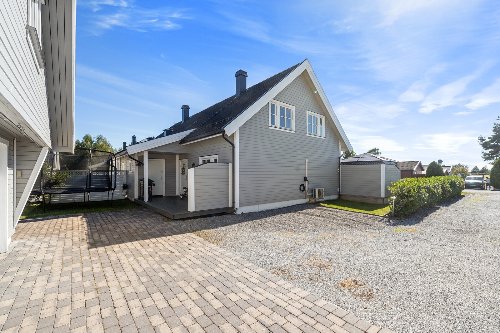 Gårdsplass med belegningsstein og platting ved inngangsparti. Zaptec ladeboks på husveggen, samt gode parkeringsmuligheter. Galleribilde