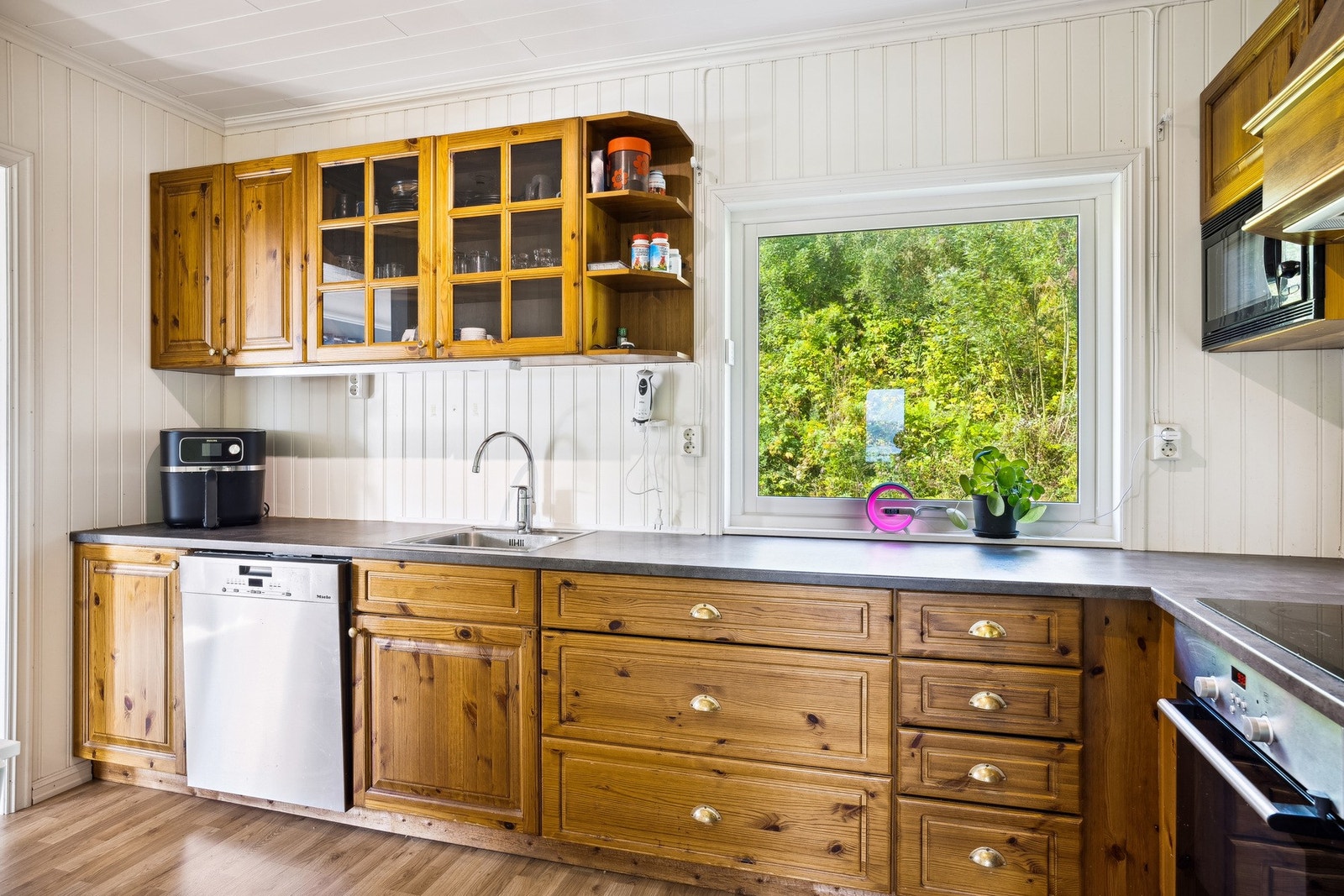 Kjøkkenet ligger innenfor stuen, med god skap- og skuffeplass i en funksjonell L-form. Galleribilde